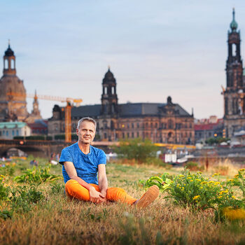 Portraitfoto von Michael Schindhelm, Kurator der Kulturhauptstadtbewerbung und Mitglied der Dresdner Delegation für die Jurypräsentation, am Elbufer mit Blick auf die Dresdner Stadtsilhouette