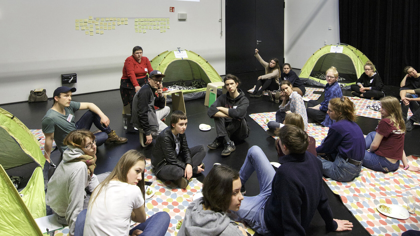 At the kick-off event for the Youth Council, numerous young people sit in a circle and discuss with each other.