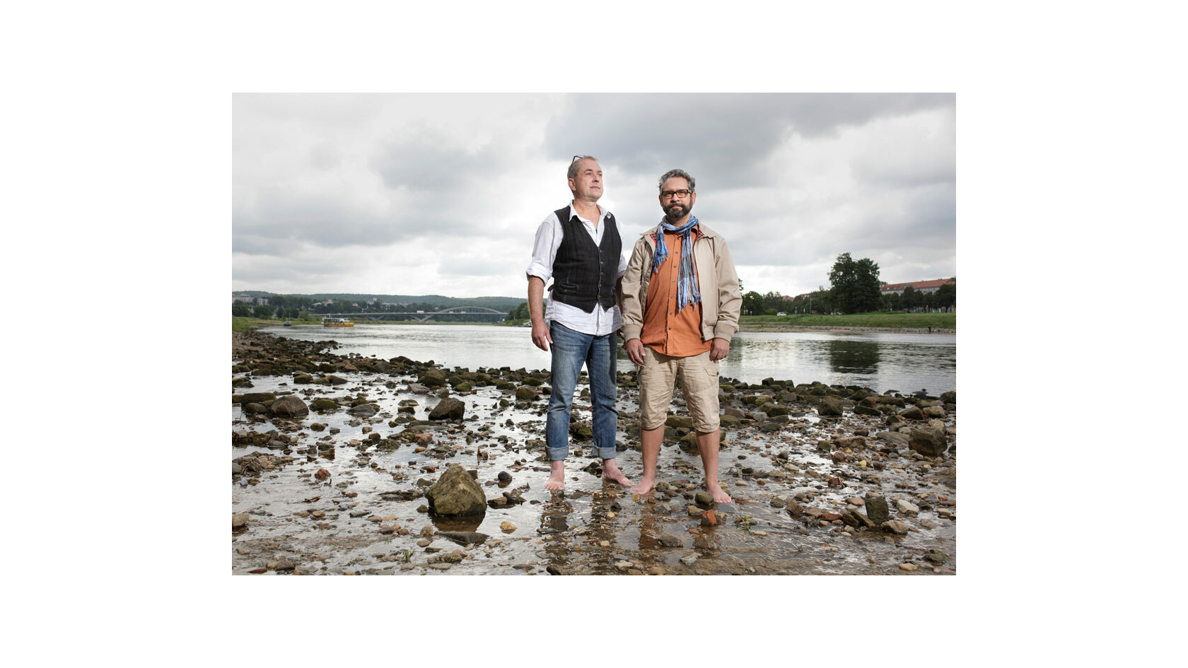Portraitfoto der Initiatoren des Projekts "You, me & mei", Jürgen Czytrich und Magnus Hecht. Sie stehen am Elbufer mit den Füßen im Wasser.