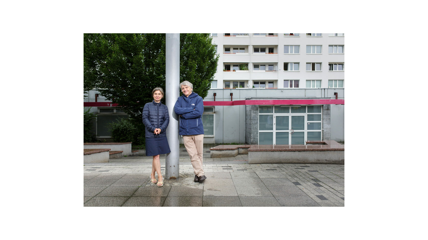 Portraitfoto der Initiatoren des Projekts "Zu Hause in Prohlis", Katrin Lindner und Andreas Nattermann. Beide stehen an einen Pfahl gelehnt im Dresdner Stadtteil Prohlis.