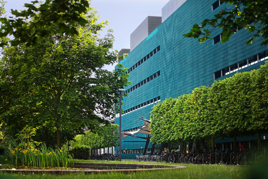 Blick auf das Max-Planck-Institut für molekulare Zellbiologie und Genetik von außen, umgeben von Bäumen und Sträuchern
