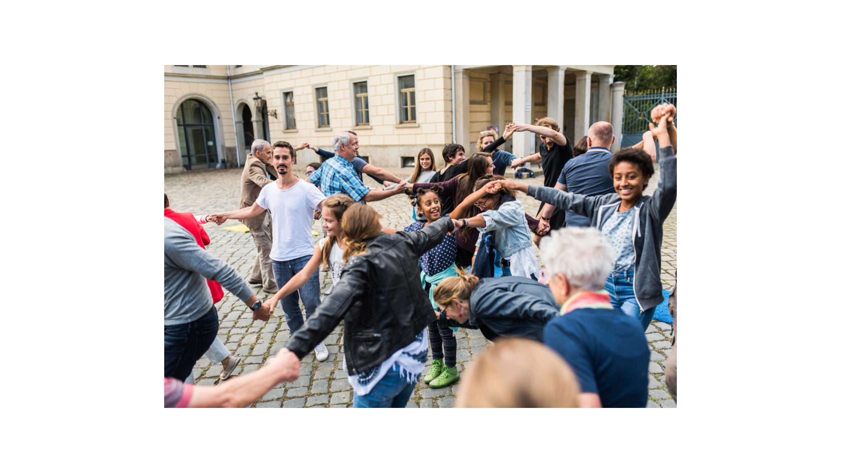 Bei den Orten des Miteinanders sind zahlreiche junge Menschen bei Schloss Albrechtsberg sich an den Händen fassend in mehreren Reihen ineinander verschlungen.