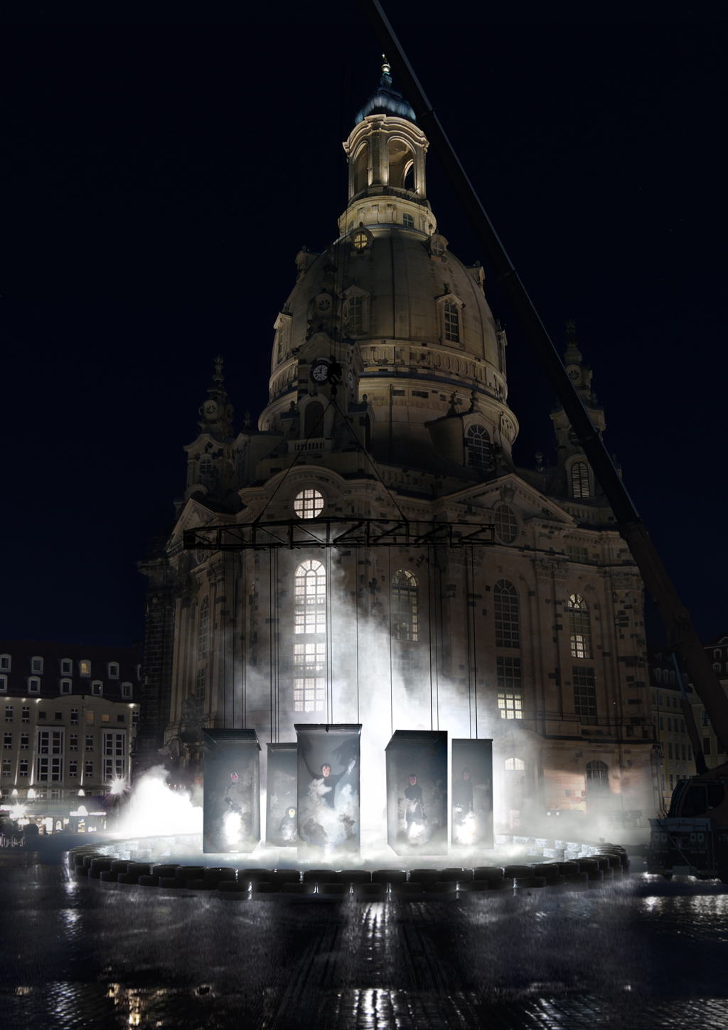 Blick auf die Kunstinstallation Kami auf dem Dresdner Neumarkt vor der Frauenkirche. An einem Kran befestigt schweben fünf menschengroße Figuren, die von Tränengas umhüllt scheinen. Die Installation zeigt Charaktere aus Protestbewegungen der letzten Jahre, die zu Medienikonen wurden.