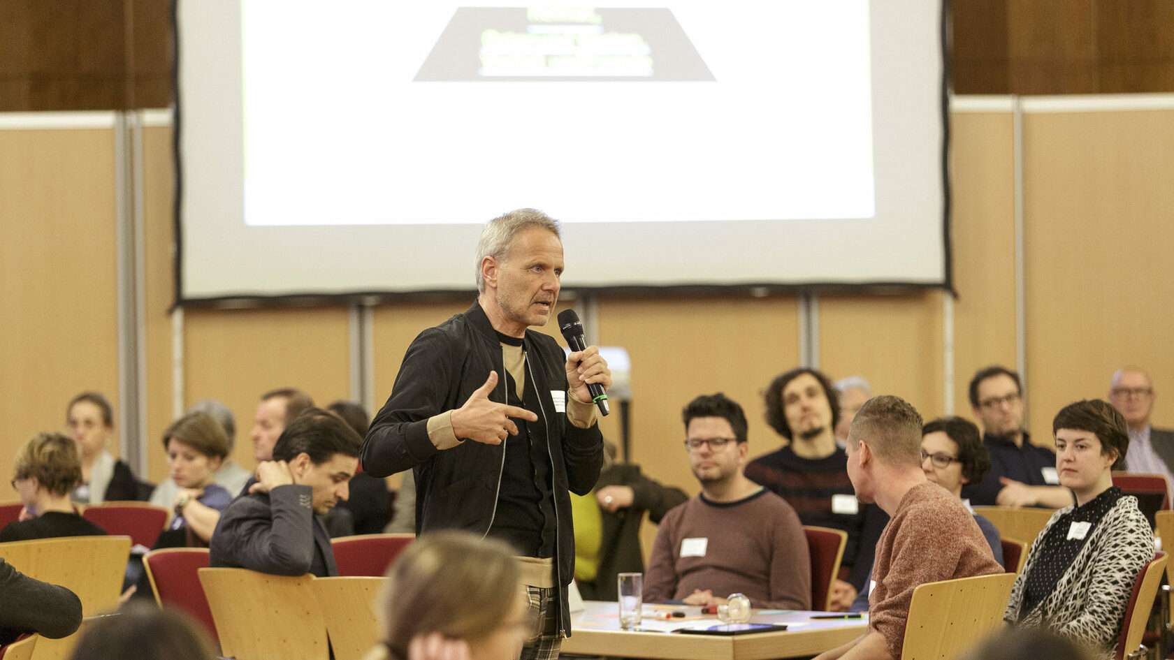 At the kick-off event for the platform process, curator Michael Schindhelm speaks to participants seated at tables in the plenary hall of City Hall.