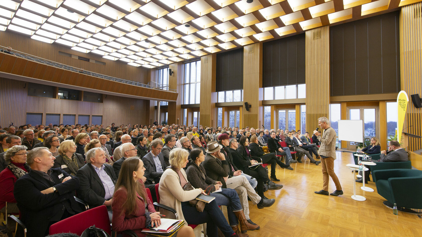 Bei der Auftakt-Veranstaltung zum Plattform-Prozess spricht der Kurator Michael Schindhelm im Rathaus vor zahlreichen Menschen, die auf Stühlen sitzen.