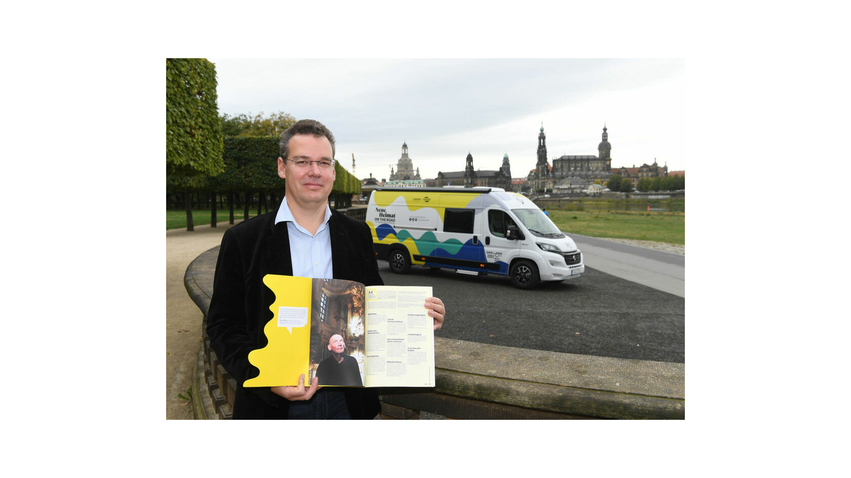 Dr. David Klein, head of the Bid Office Dresden 2025, presents the bid book on the banks of the Elbe river in Dresden.