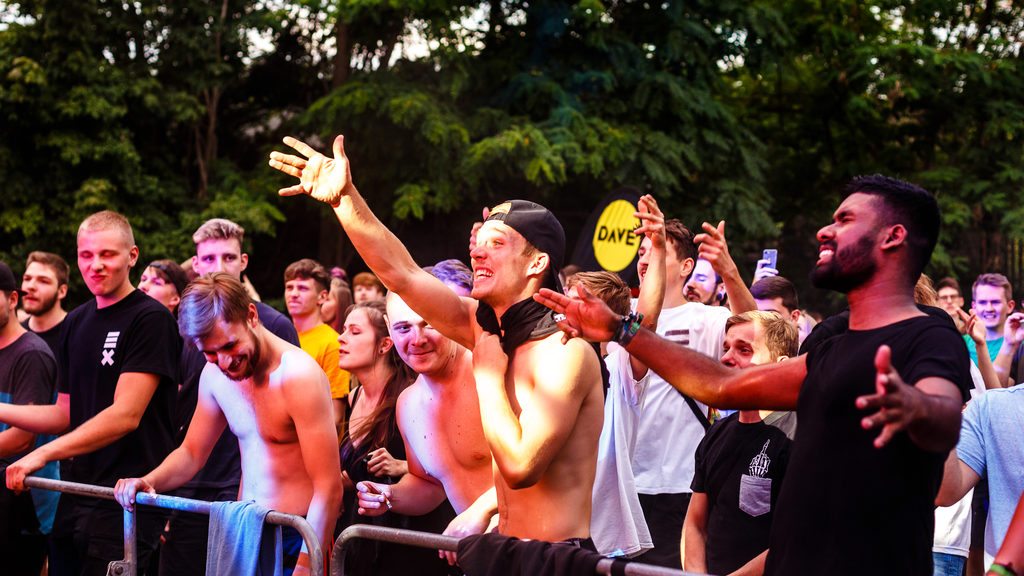 Blick auf ein junges Publikum bei der Dresden Urban Dance Experience, das vor einer Bühne feiert.