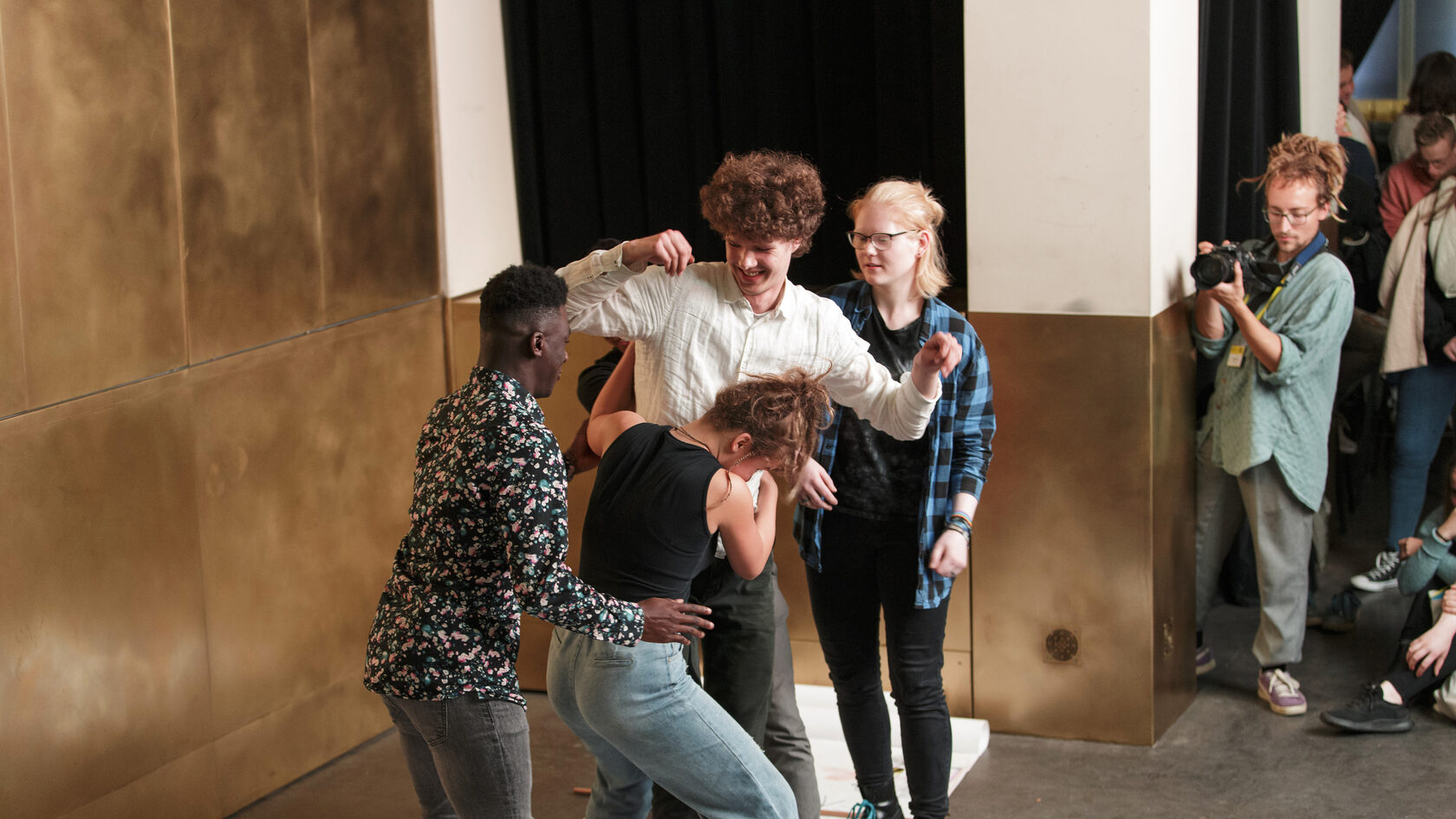 Performance of a group of young people moving towards each other, observed by the audience.