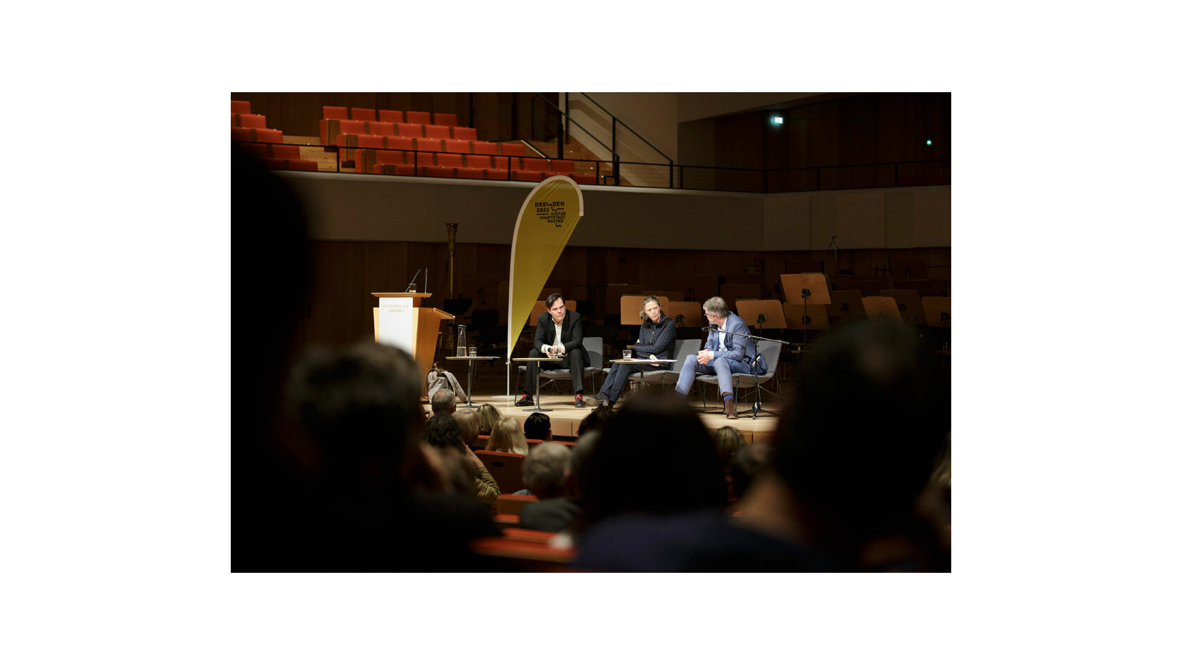 Blick auf das Podium der Dresdner Diskussionsreihe „Streitbar!“ mit den beiden Autoren Uwe Tellkamp und Durs Grünbein sowie Moderatorin Karin Großmann im Dresdner Kulturpalast.
